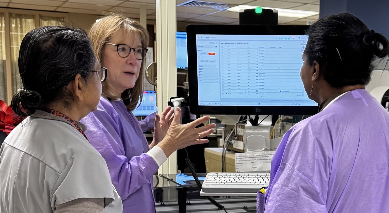 Susan Dawson teaching technologists at an analyzer screen